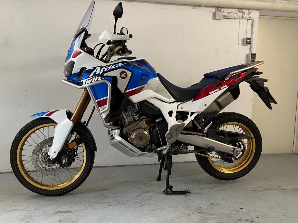 In einer Garage steht ein blau-weiß-rotes Motorrad.