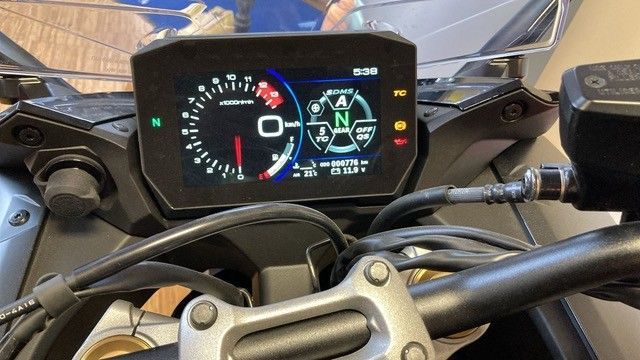 Motorrad-Armaturenbrett mit Tachometer, Ganganzeige und anderen Anzeigen; Details in Schwarz, Weiß und Rot.