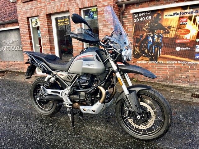 Vor einem Backsteingebäude ist ein Motorrad geparkt.