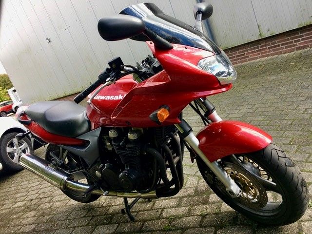 Ein rotes Kawasaki-Motorrad steht auf einer gemauerten Auffahrt