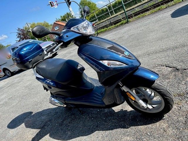 Ein blauer Roller steht am Straßenrand