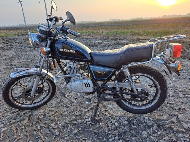 Ein schwarzes Suzuki-Motorrad ist auf einem Feld geparkt.