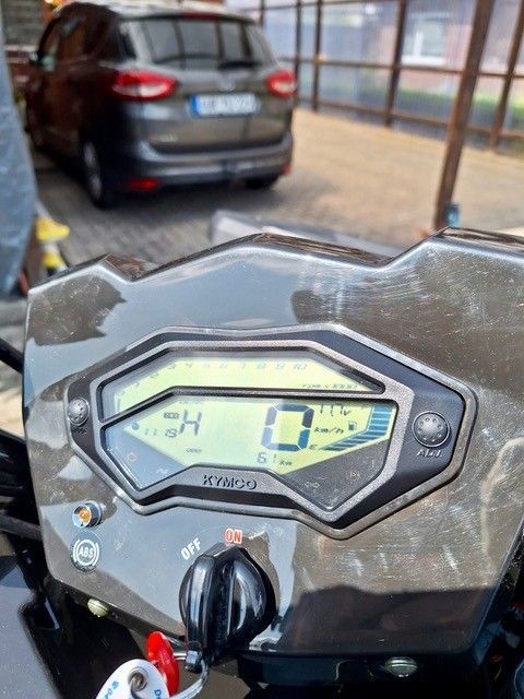 Armaturenbrett eines Geländewagens. Das Display zeigt 0 km/h, im Hintergrund ist ein Fahrzeug zu sehen. Die Szene spielt im Freien.