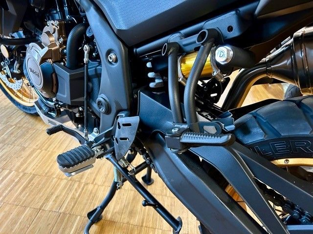 Ein schwarzes Motorrad ist auf einem Holzboden geparkt