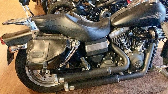 Ein schwarzes Harley-Davidson-Motorrad ist auf einem Holzboden geparkt.