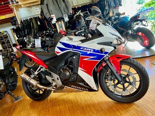 Ein rot-weiß-blaues Honda-Sportmotorrad ist in einem Geschäft ausgestellt.