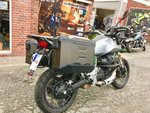 Vor einem Backsteingebäude ist ein Motorrad geparkt.