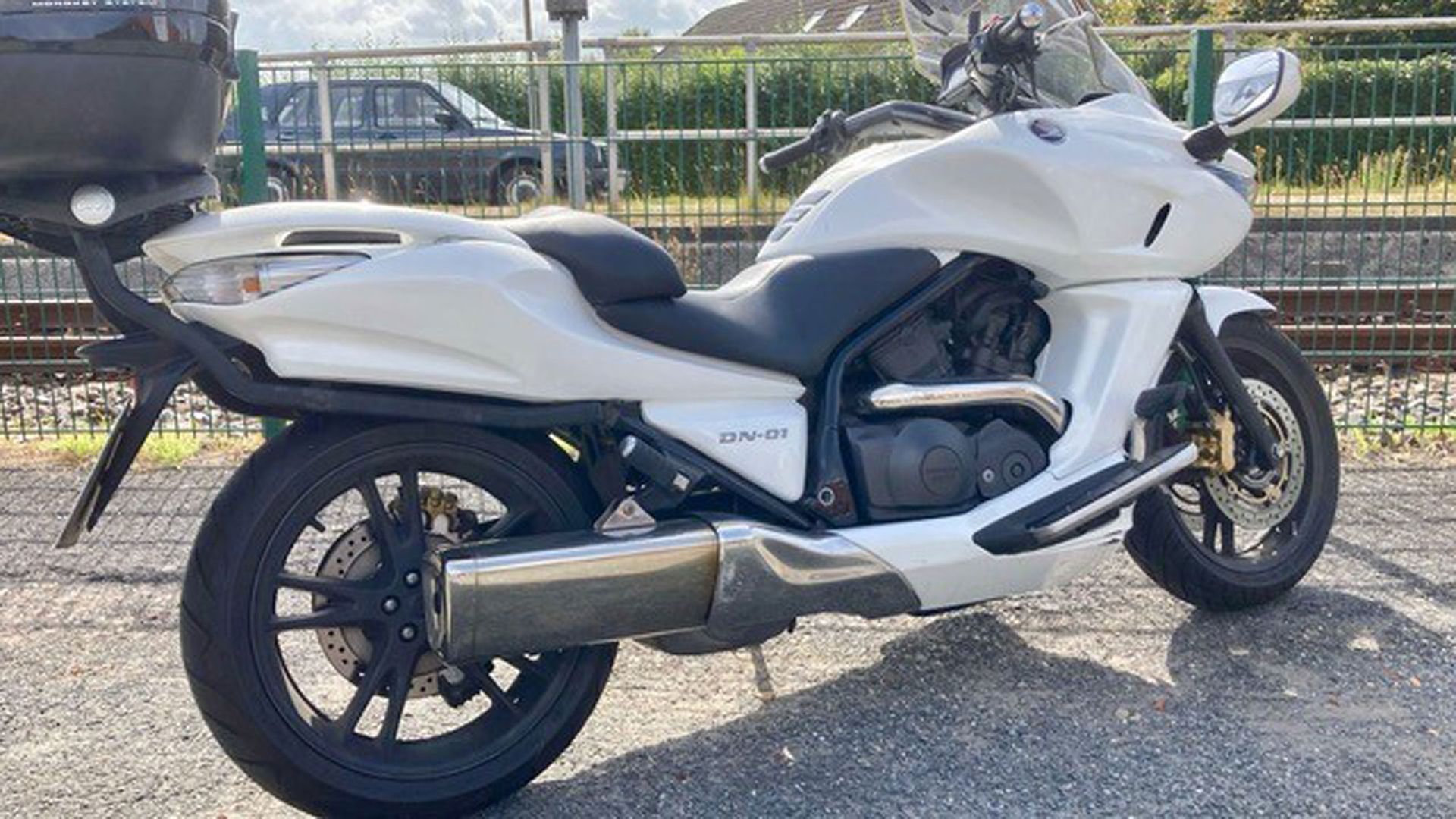 Weißes Honda NM4-Motorrad, in der Nähe von Bahngleisen geparkt.
