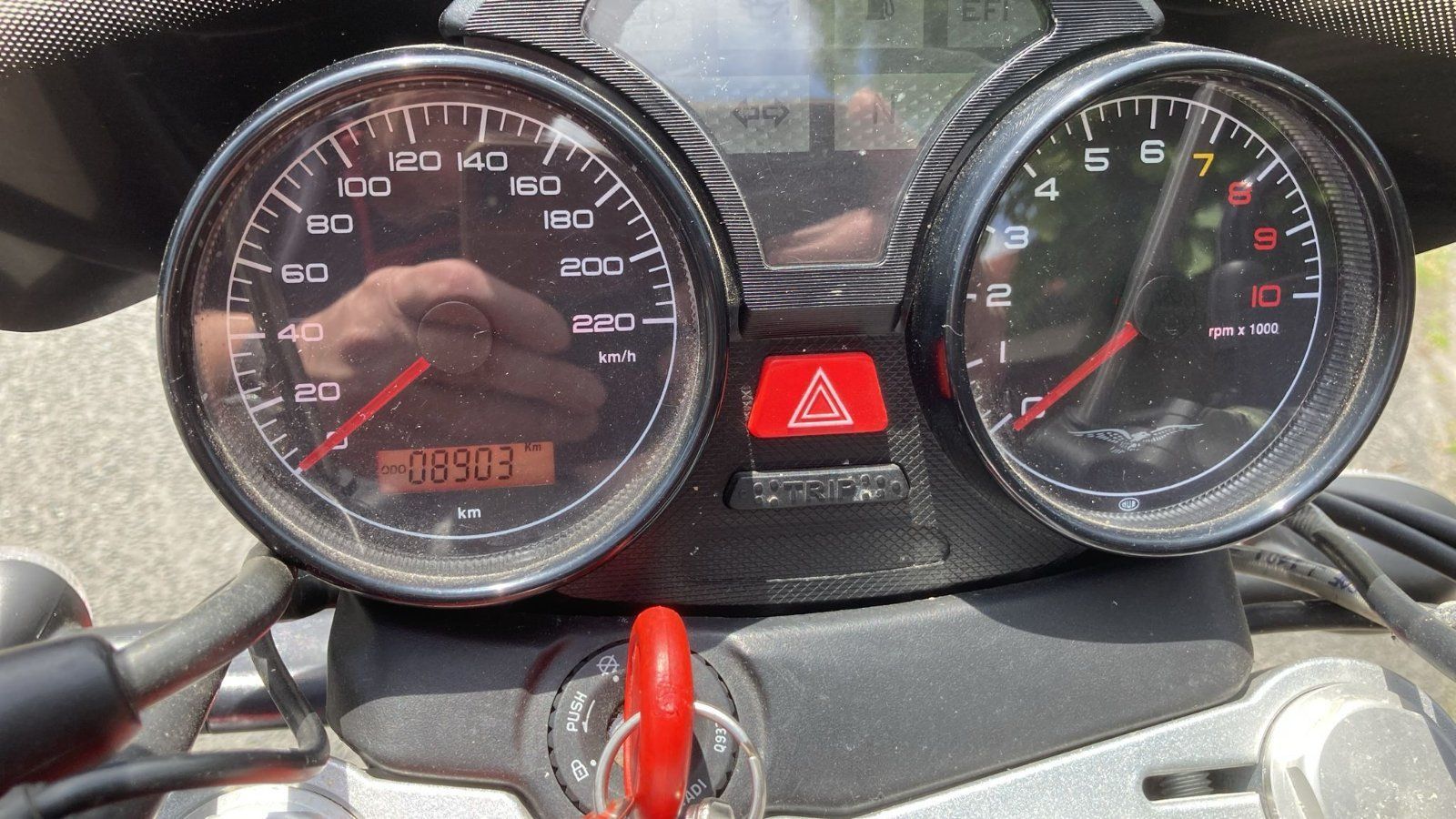 Eine Nahaufnahme eines Motorrad-Armaturenbretts mit einem roten Dreieck darauf