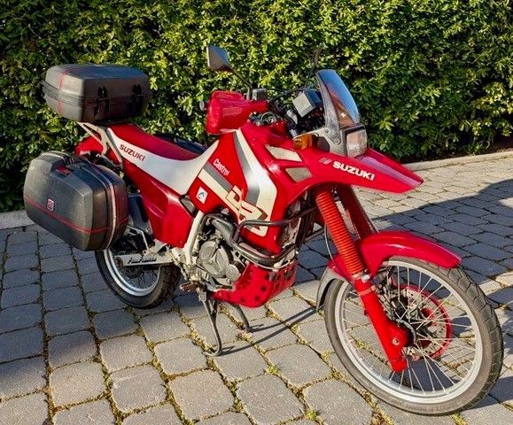 Ein rotes Suzuki-Motorrad ist auf einer gemauerten Auffahrt geparkt