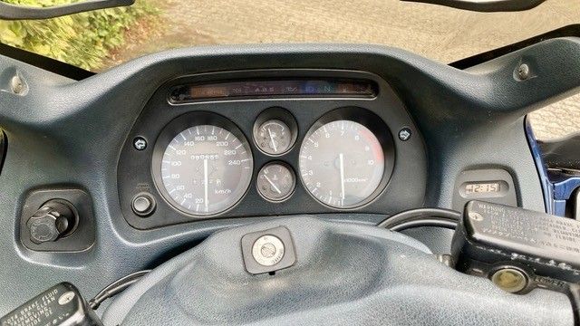 Motorrad-Armaturenbrett mit Tachometer, Anzeigen und Schlüsselzündung. Graue und schwarze Farben.