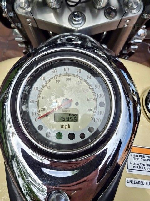 Nahaufnahme eines verchromten Motorradtachos mit einem Kilometerstand von 15559 Meilen.