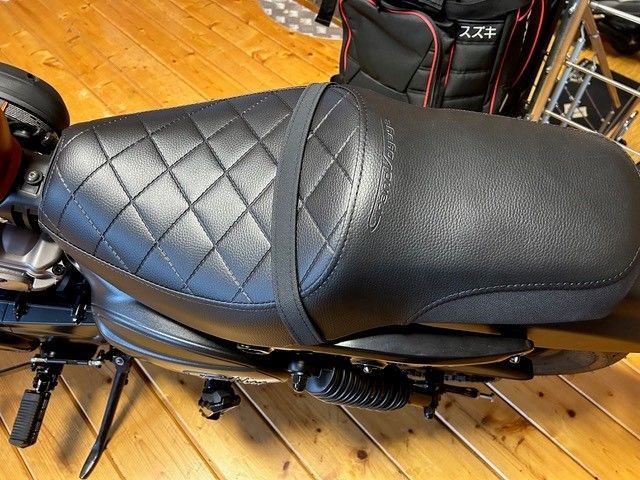 Ein schwarzes Motorrad ist auf einem Holzboden geparkt