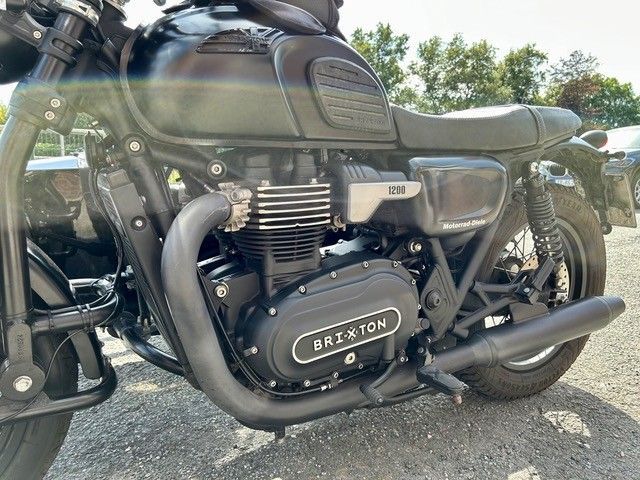 Schwarzes Motorrad mit „Brixton“-Logo auf dem Motor, draußen geparkt.