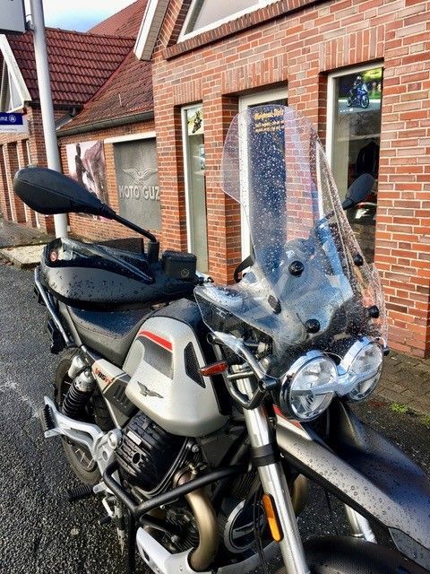 Vor einem Backsteingebäude ist ein Motorrad geparkt.