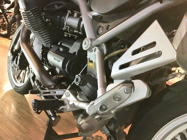 Ein Motorrad steht auf einem Holzboden in einem Ausstellungsraum