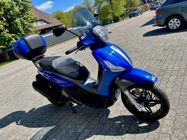 Ein blauer Roller steht am Straßenrand
