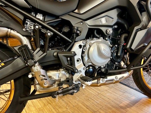 Der Motor eines Motorrads steht auf einem Holzboden.