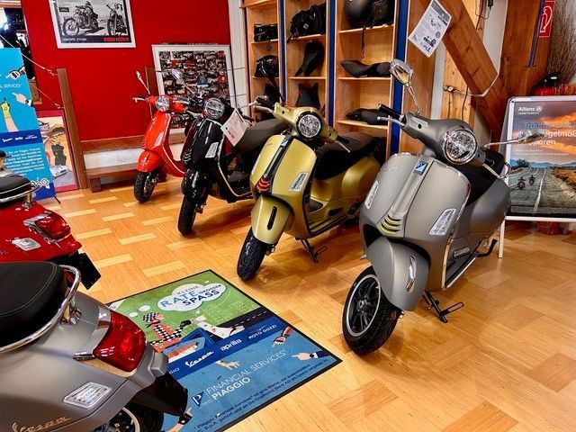 Roller-Showroom: Mehrere Vespa-Roller in verschiedenen Farben ausgestellt.