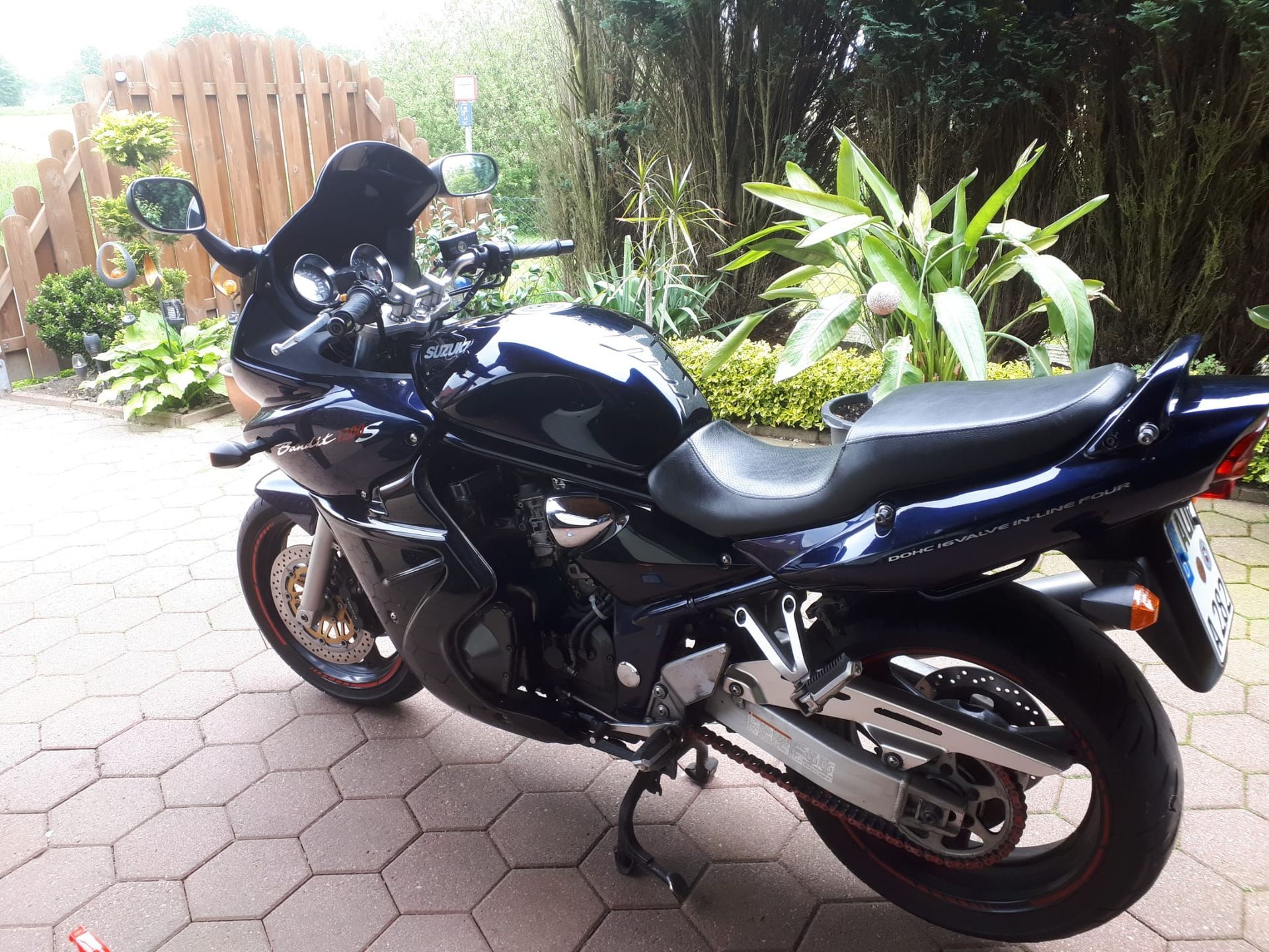 Ein schwarzes Motorrad ist auf einer gemauerten Auffahrt geparkt