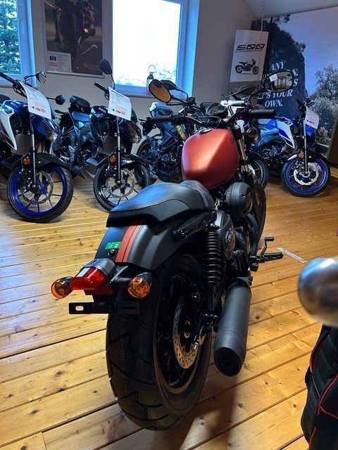 Ein rot-schwarzes Motorrad steht in einem Ausstellungsraum