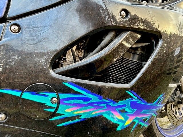 Eine Nahaufnahme eines Motorrads mit einem blauen und violetten Design an der Seite.