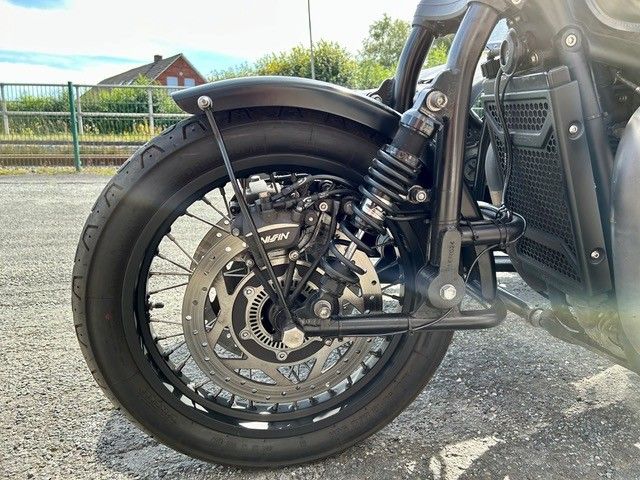 Nahaufnahme des Vorderrads eines Motorrads. Schwarzer Reifen, Bremsscheibe, Aufhängung und Kotflügel sind sichtbar.