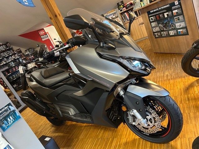 In einem Ausstellungsraum mit Holzboden ist ein Motorrad geparkt.