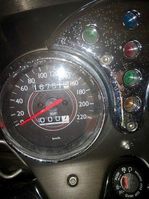 Motorradtacho mit 167542 km, umgeben von Kontrollleuchten und Zündung.