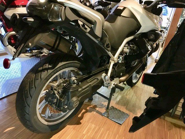 Ein Motorrad ist auf einem Holzboden geparkt