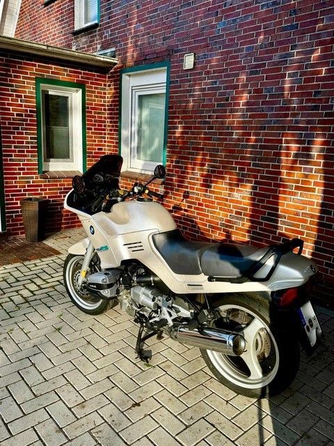 Vor einem Backsteingebäude ist ein Motorrad geparkt.