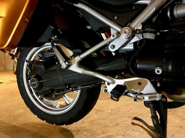 Ein Motorrad ist auf einem Holzboden in einer Garage geparkt