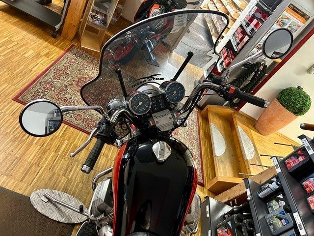 Motorrad mit Windschutzscheibe und Spiegeln in einem Geschäft oder Ausstellungsraum, von oben gesehen