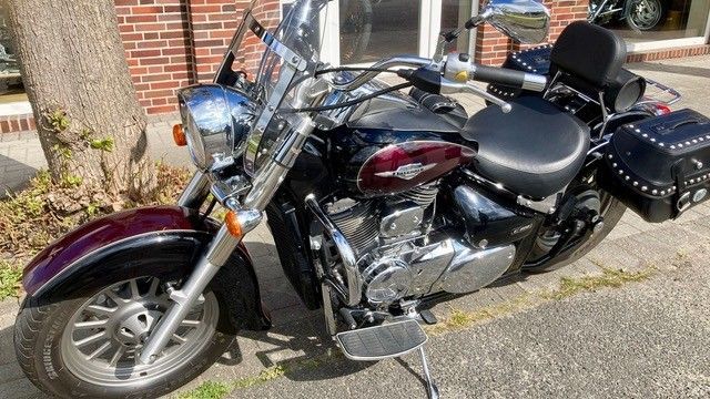 Ein Motorrad ist am Straßenrand vor einem Backsteingebäude geparkt.