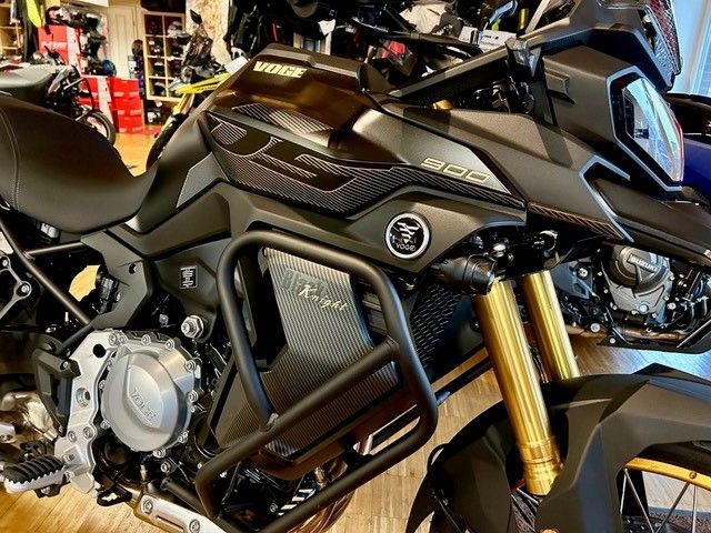 Ein schwarzes Motorrad steht auf einem Holzboden in einer Garage.