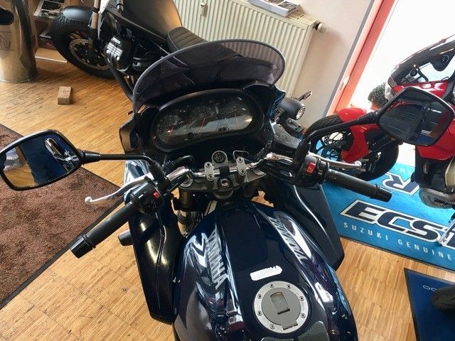 Ein Motorrad ist vor einem Schild mit der Aufschrift ECS geparkt