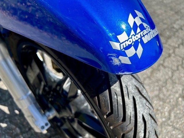 Eine Nahaufnahme eines blauen Motorrads mit einem Motorradaufkleber auf dem vorderen Kotflügel