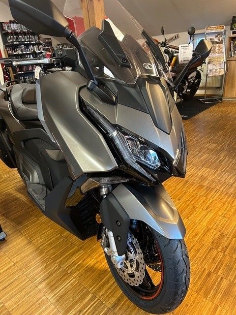 In einem Ausstellungsraum steht ein Motorrad auf einem Holzboden.