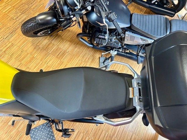 Draufsicht auf ein schwarzes Motorrad mit großem Topcase auf einem Holzboden