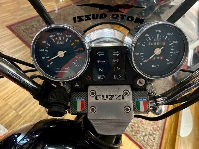 Nahaufnahme eines Motorrad-Armaturenbretts mit zwei analogen Instrumenten und verchromtem Lenker.