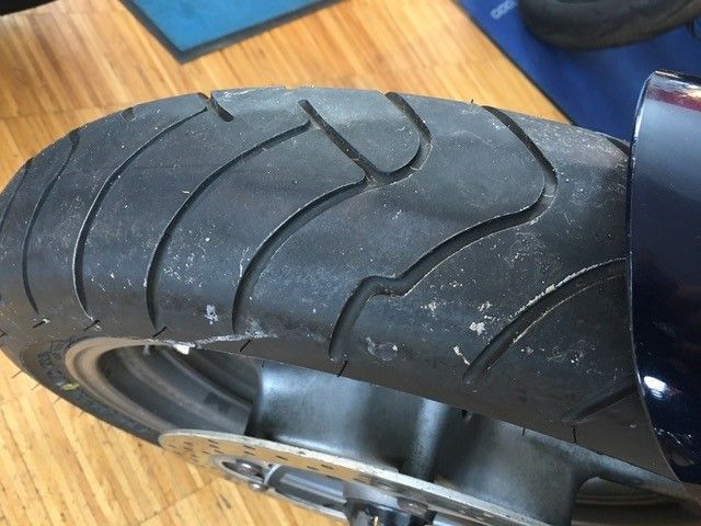 Eine Nahaufnahme eines Motorradreifens auf einem Holzboden