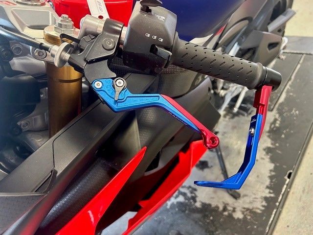 Verstellbare Kupplungs- und Bremshebel für Motorräder in Blau und Rot an einem schwarzen Lenker