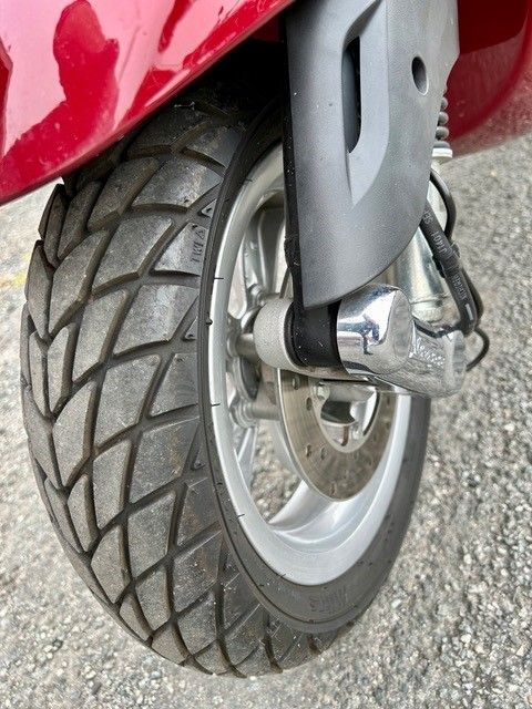 Eine Nahaufnahme eines Reifens auf einem roten Roller