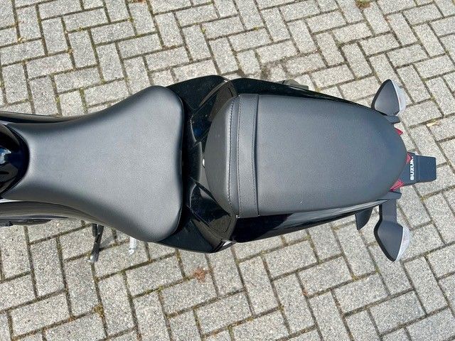 Draufsicht auf ein graues Motorrad, das auf einer gepflasterten Fläche geparkt ist