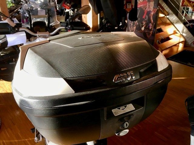 In einem Geschäft steht auf dem Holzboden ein Motorradkoffer.