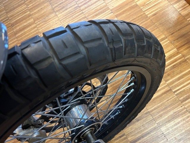 Eine Nahaufnahme eines Motorradreifens auf einem Holzboden