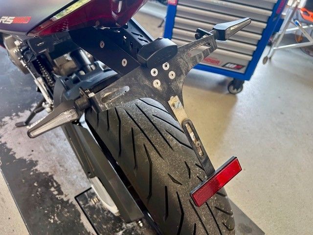 Nahaufnahme eines Motorradhinterreifens, Kotflügels und Heckteils in einer Garage.