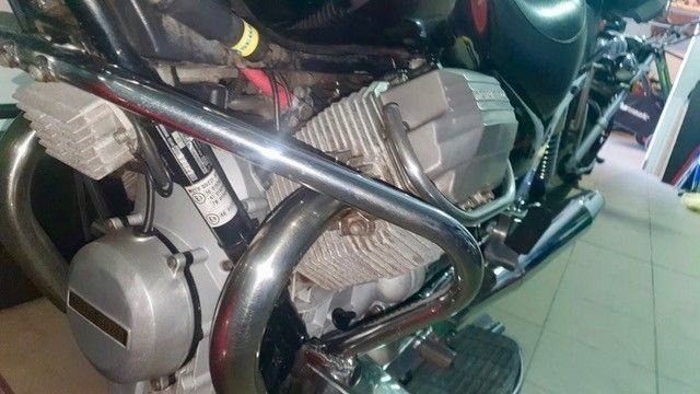 Motorradmotor mit verchromten Schutzbügeln. Silberne und schwarze Bauteile sichtbar.