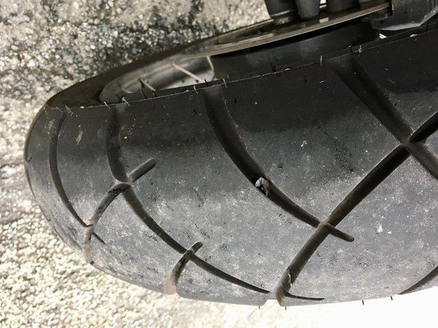 Eine Nahaufnahme eines Motorradreifens auf einer Betonoberfläche.