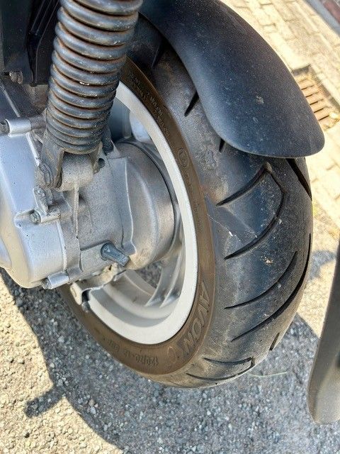 Eine Nahaufnahme eines Motorradreifens auf einer Straße.